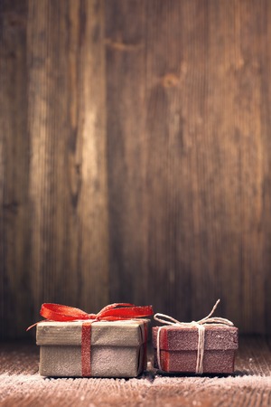 Snow-covered Xmas gift boxes against wooden backgroundの写真素材