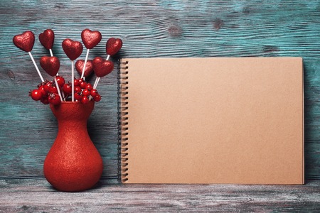 Valentines day decoration and blank note pad over old wooden backgroundの写真素材