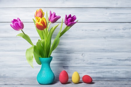Still life with painted eggs and tulips in vaseの写真素材