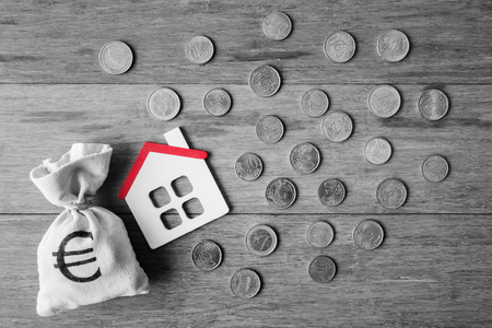 Top view of house model and Euro coins over wooden backgroundの写真素材