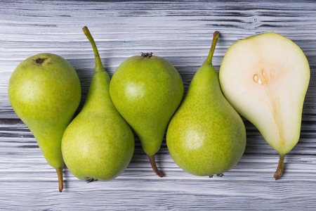 Green pears row over rustic wooden backgroundの写真素材
