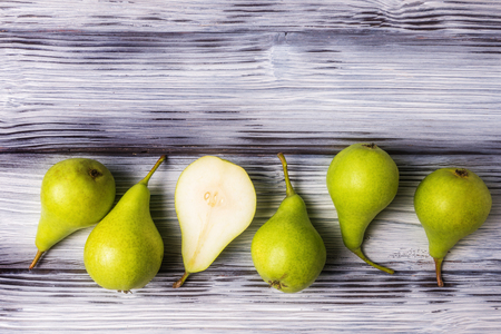 Top view of green pears row over rustic wooden backgroundの写真素材