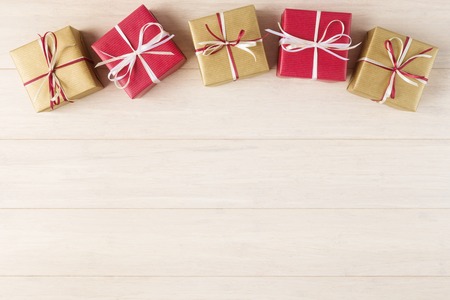 Red and yellow gift boxes over wooden background with copy space