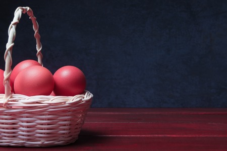 Painted eggs in basket over dark stone background with copy space.の写真素材