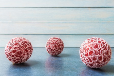 Three red Christmas balls over light blue wooden  with copy space.