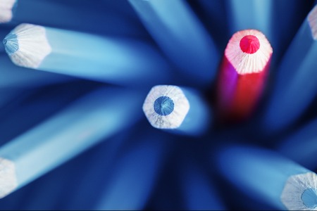 One red pencil among of blue toned groupの写真素材