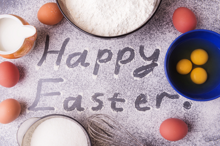 Ingredients for dough preparation. Happy easter inscription on flourの写真素材