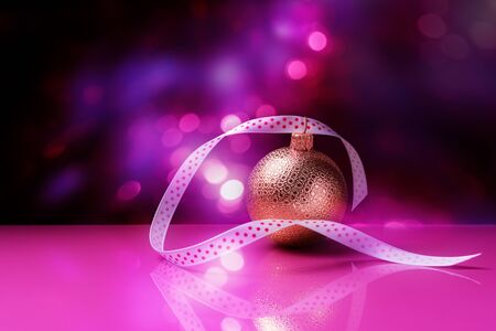 Christmas bauble with long ribbon over holiday lightsの写真素材