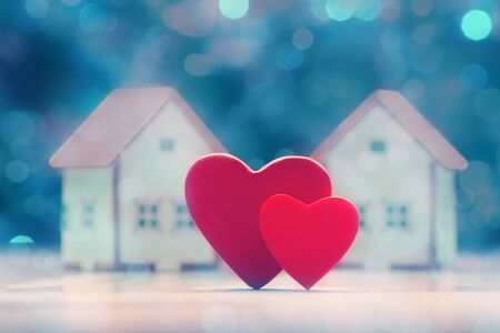 Two hearts and house models over defocused lights. Valentine's day conceptの写真素材