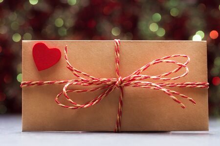 Envelope with bow and red heart over holiday background. Valentines day concept. Vintage stylized...