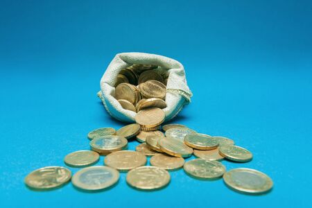 Euro coins in open bag on blue backgroundの写真素材