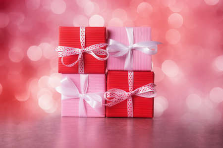 Red and pink gift boxes against defocused lightsの写真素材