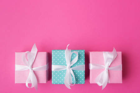 Blue and pink gift boxes with white bows on rose background with copy spaceの写真素材