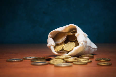 Open money bag with Euro coins on dark blue backgroundの写真素材