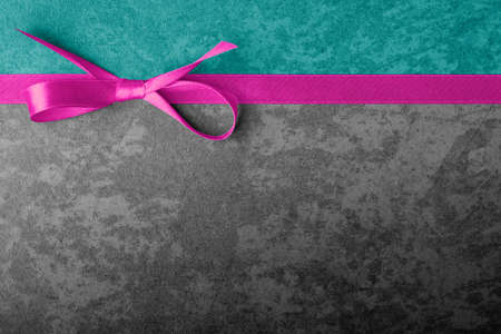 Decorative bow and ribbon on texture dark background with copy spaceの写真素材