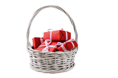 Red gift boxes in white basket isolated in white backgroundの写真素材