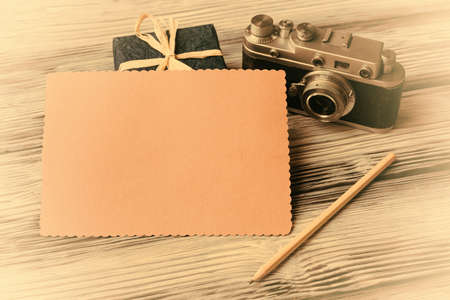 Blank card with old camera and gift box on vintage wooden backgroundの写真素材