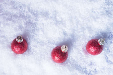 Three red Christmas balls in snow. Xmas and New Year conceptの写真素材