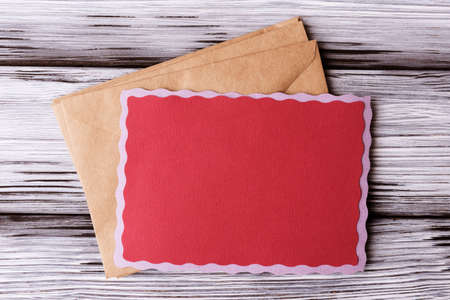 Blank red greeting card and craft envelopes on wooden backgroundの写真素材