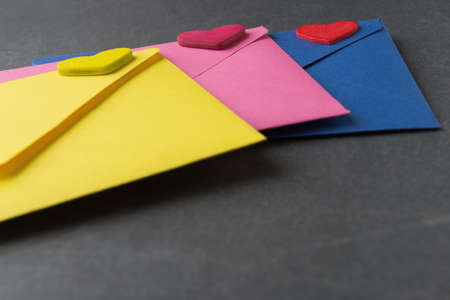 Multicolor envelope with decorative Valentineâ€™s hearts on grey background