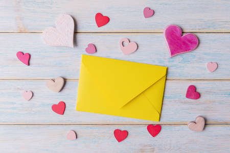 Yellow envelope and Valentineâs hearts on blue wooden backgroundの写真素材