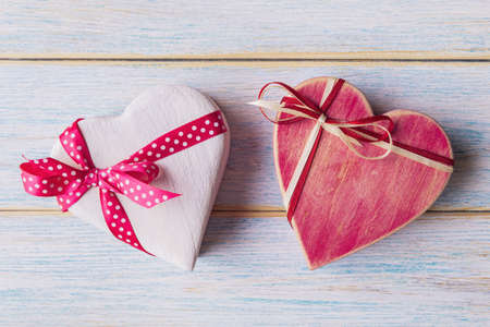 Two heart shaped gift boxes on light wooden backgroundの写真素材