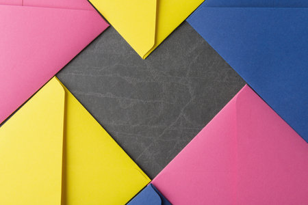 Flat lay of multicolor envelopes on stone background. Heart shape layout. Valentineâs Day backgroundの写真素材
