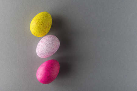 Colored Easter eggs on grey background with copy space
