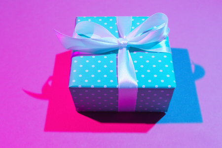Close up of gift box on light pink background. Double colorful shadowsの写真素材