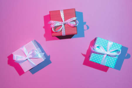 Three gift boxes over light pink background. Double colorful shadowsの写真素材