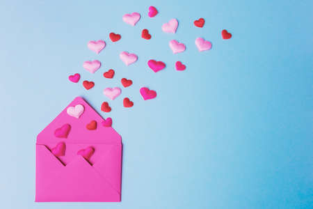 Open pink envelope and decorative heartsの写真素材