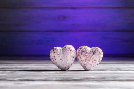 Two hearts over wooden background with blue backlight. Valentines day greeting conceptの写真素材