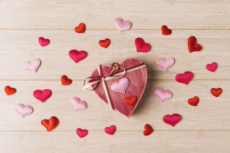 Heart shaped gift box on light wooden background. Valentineâ€™s day holiday greeting