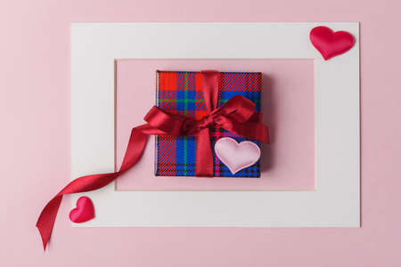 White frame, gift box and decorative Valentines hearts on light pink background. Valentines day conceptの写真素材