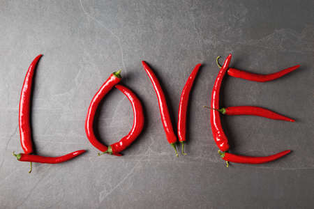 Word Love made of red hot peppers on grey stone background. Valentines day greeting conceptの写真素材