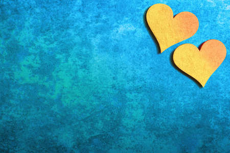 Two yellow hearts on blue stone background with copy space. Valentines day backgroundの写真素材