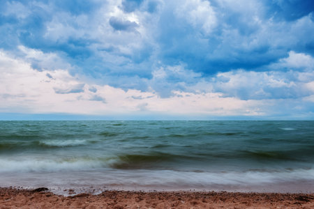Stormy sky with dramatic clouds over lake water with big wavesの写真素材