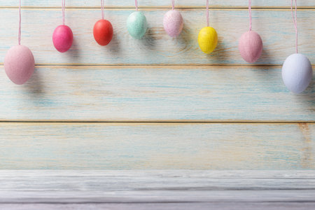 Easter multicolored decorative eggs over wooden background with copy spaceの写真素材