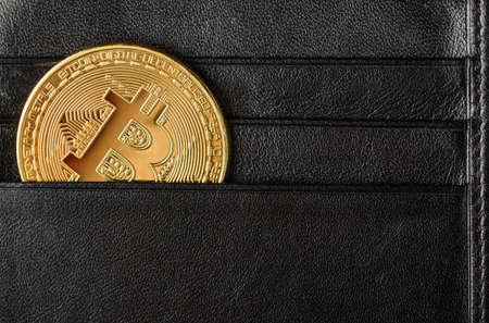 Metallic bitcoin in a black wallet. Ð¡oncept of cryptocurrency and blockchainの写真素材