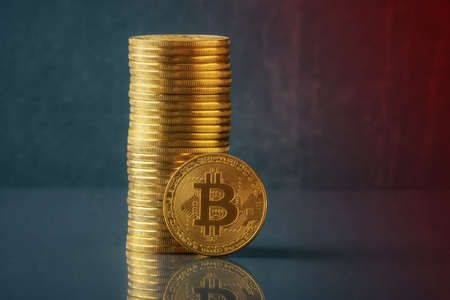 Bitcoin coins stack over defocused blue red background with copy space. Cryptocurrency conceptの写真素材