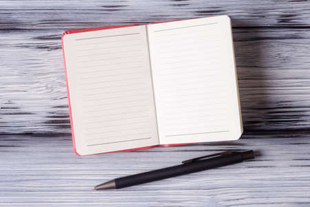 Open blank notebook with pen on aged wooden backgroundの写真素材