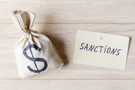 Money bag and label with word sanctions. Contemporary political and economic problems conceptの写真素材