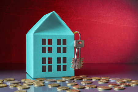House model with keys and Euro coins over red background with copy spaceの写真素材