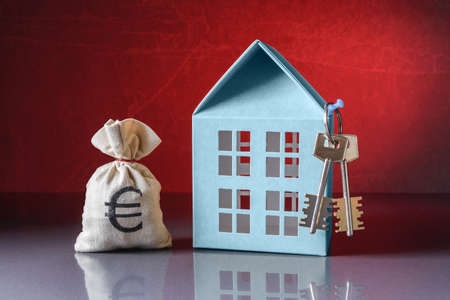 Money bag with Euro symbol, House with keys over red backgroundの写真素材
