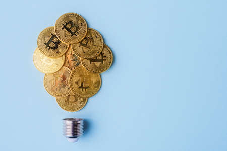 Bitcoins arranged in a shape of light bulb on blue background with copy space. Cryptocurrency and virtual money conceptの写真素材