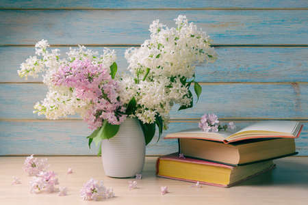 Still Life with Books and Bouquet of Flowering Lilacs over wooden backgroundの写真素材