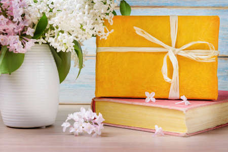 Still Life with Yellow Gift Box and Bouquet of Flowering Lilacsの写真素材
