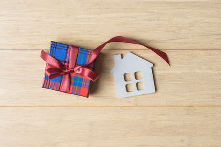 Gift box and house model on wooden backgroundの写真素材