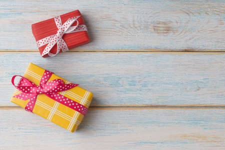 Red and yellow gift boxes on wooden background with copy spaceの写真素材