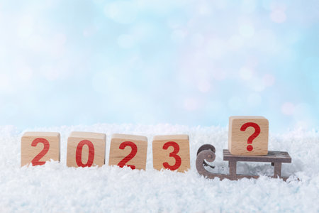 Wooden blocks with the numbers 2023 and a block with a question mark on a sled. Ð¡oncept of an uncertain future in the coming yearの写真素材